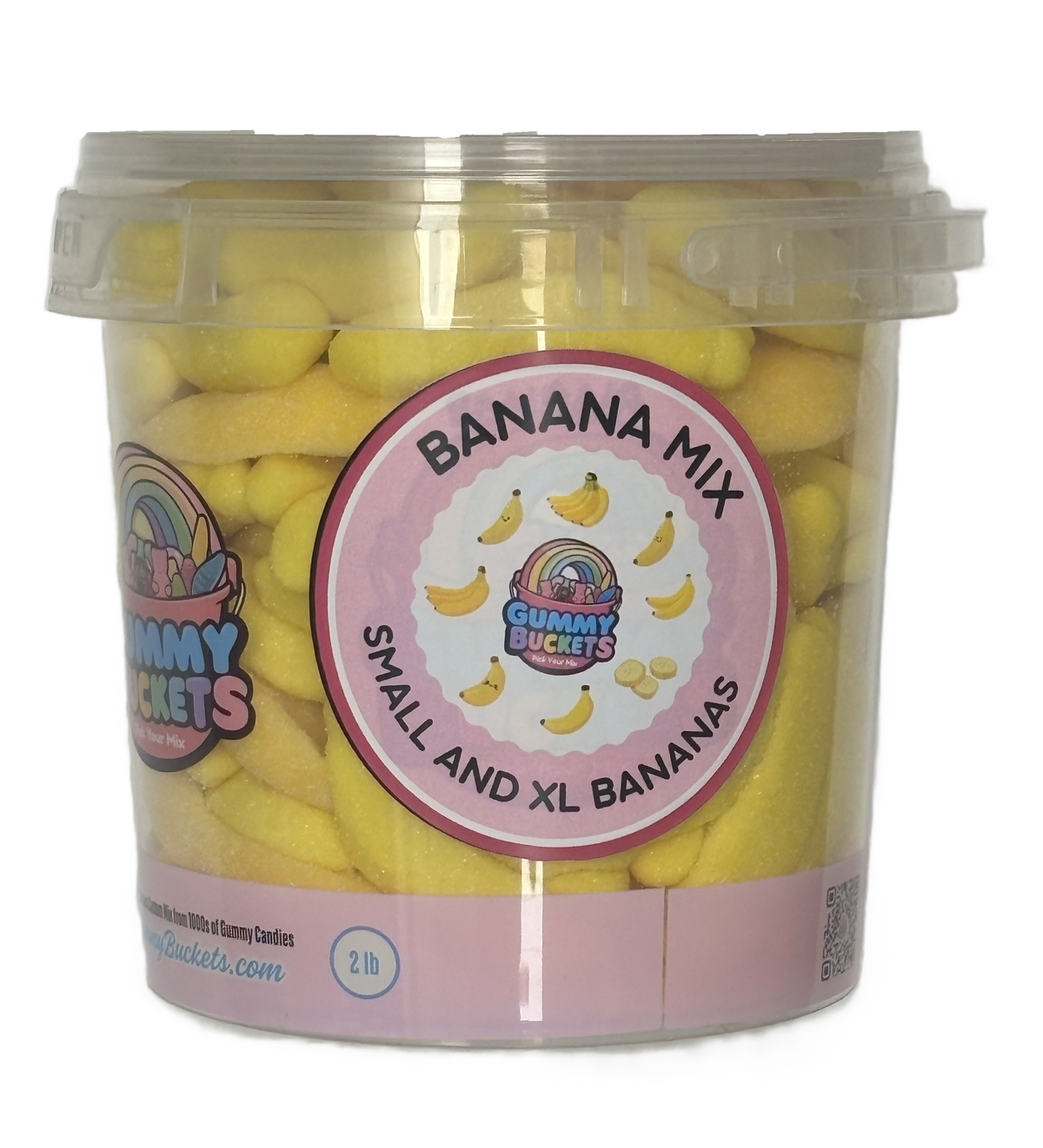 A 2 lb clear plastic tub filled with yellow banana-shaped candies, labeled 'BANANA MIX' and 'SMALL AND XL BANANAS' by the brand Cummy Buckets. The tub has a clear lid and a pink and white label.