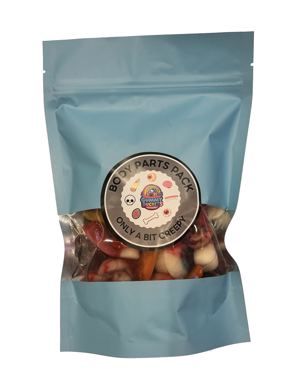 A light blue resealable stand-up pouch with a clear window showing creepy gummy candies shaped like teeth, eyeballs, fingers, and body parts in red, white, and flesh tones inside. A round dark gray label on the front reads 'BODY PARTS PACK' and 'ONLY A BIT CREEPY' with the Gummy Buckets logo surrounded by illustrated skull, bone, and body part icons in the center.