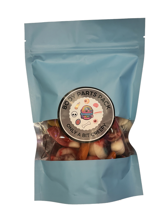 A light blue resealable stand-up pouch with a clear window showing creepy gummy candies shaped like teeth, eyeballs, fingers, and body parts in red, white, and flesh tones inside. A round dark gray label on the front reads 'BODY PARTS PACK' and 'ONLY A BIT CREEPY' with the Gummy Buckets logo surrounded by illustrated skull, bone, and body part icons in the center.
