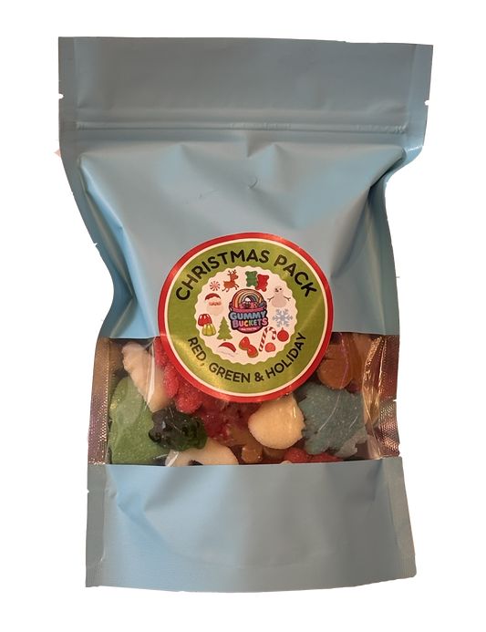 A light blue stand-up pouch of candy with a clear window showing assorted multicolored gummy candies inside. A circular front label reads 'CHRISTMAS PACK' with a holiday graphic.