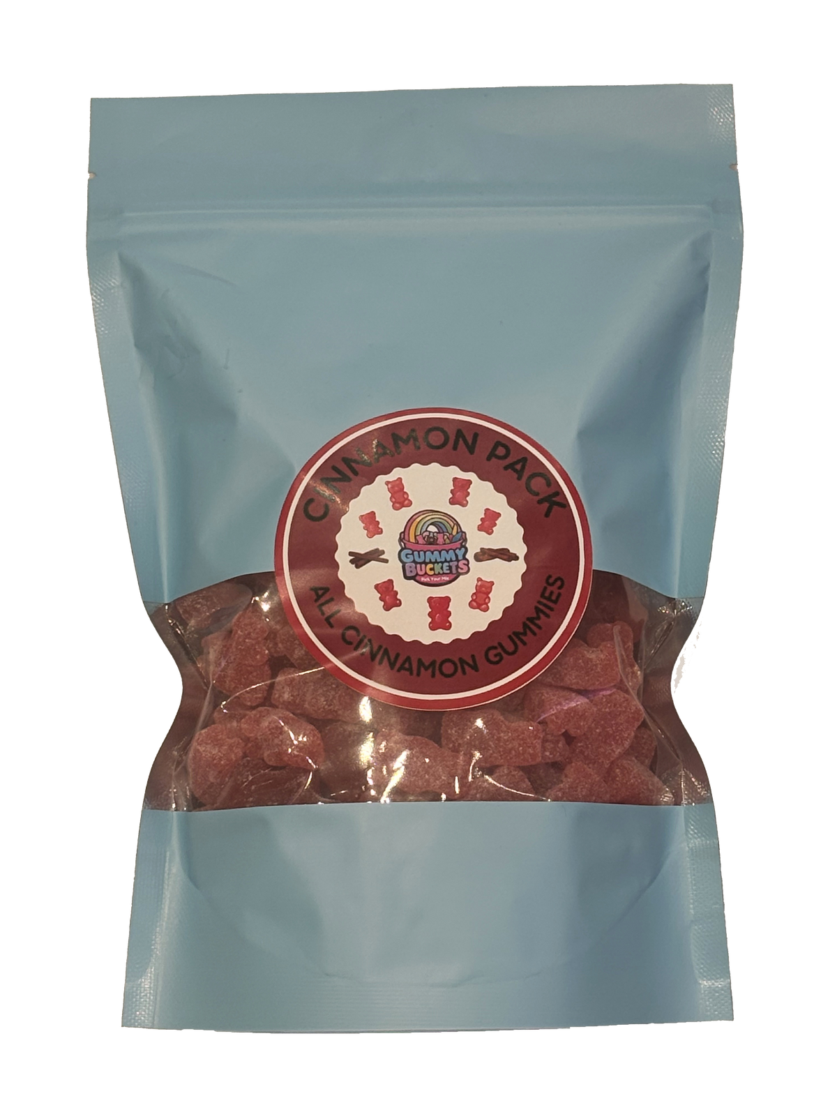 A light blue resealable stand-up pouch of candy gummies with a clear window showing reddish-brown cinnamon pack gummies inside. A round red and white label on the front reads 'CINNAMON PACK' and 'ALL CINNAMON GUMMIES' with a small logo in the center.
