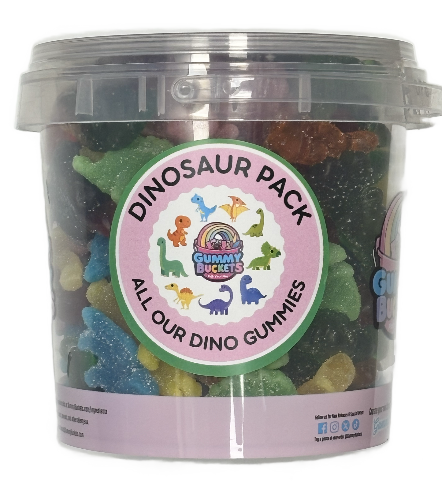A clear plastic bucket filled with assorted dinosaur-shaped gummy candies, featuring a round pink and green label that reads 'DINOSAUR PACK' and 'ALL OUR DINO GUMMIES.'.