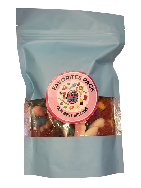 A light blue resealable stand-up pouch with a clear window showing a colorful assortment of best-selling gummy candies including worms, bears, peach rings, and fruit shapes inside. A round pink label on the front reads 'FAVORITES PACK' and 'OUR BEST SELLERS' with the Gummy Buckets logo surrounded by illustrated candy icons in the center.