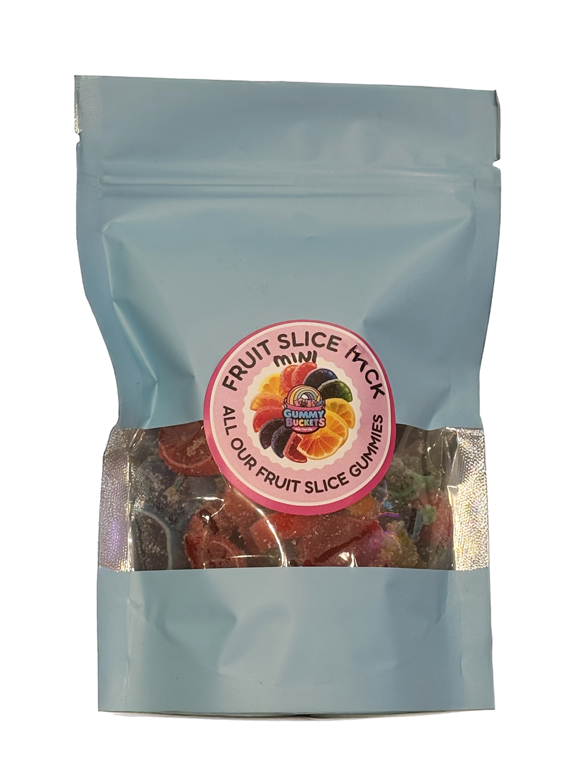 A light blue resealable stand-up pouch with a clear window showing small mini fruit slice gummy candies in red, orange, yellow, and black inside. A round pink label on the front reads 'FRUIT SLICE PACK MINI' and 'ALL OUR FRUIT SLICE GUMMIES' with the Gummy Buckets logo surrounded by illustrated fruit slice candy icons in the center.