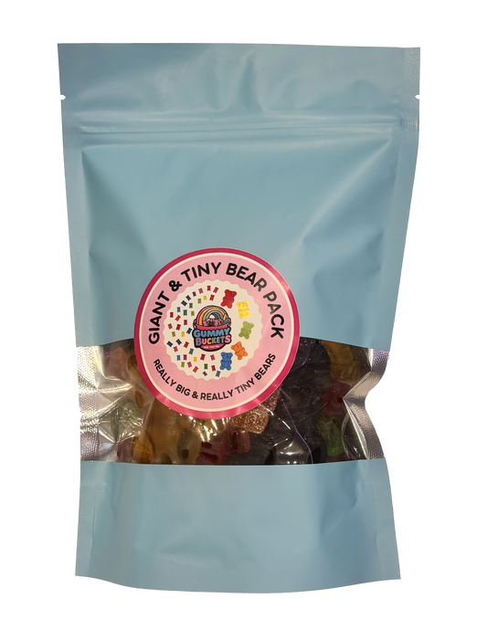 A light blue resealable stand-up pouch with a clear window showing a mix of oversized giant gummy bears and mini tiny gummy bears in red, orange, yellow, green, and purple inside. A round pink label on the front reads 'GIANT & TINY BEAR PACK' and 'REALLY BIG & REALLY TINY BEARS' with the Gummy Buckets logo surrounded by illustrated large and small bear icons in the center.