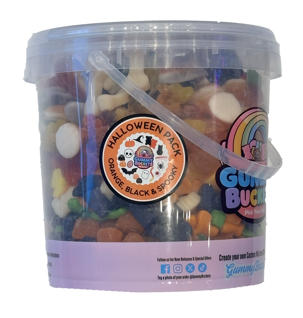 A clear plastic bucket filled with assorted Halloween-themed gummy candies, featuring a purple label with a rainbow logo and a circular sticker that reads 'Halloween Pack Orange, Black & Spooky'.