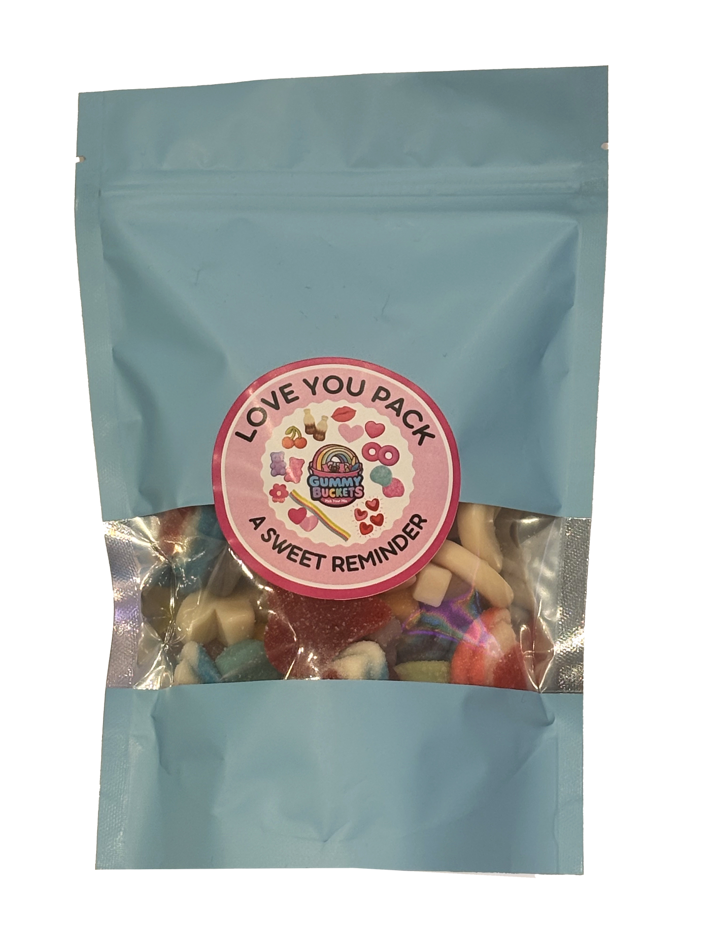 A light blue resealable stand-up pouch with a clear window showing a romantic assortment of gummy candies including hearts, lips, and pastel-colored shapes inside. A round pink label on the front reads 'LOVE YOU PACK' and 'A SWEET REMINDER' with the Gummy Buckets logo surrounded by illustrated heart and love-themed candy icons in the center.