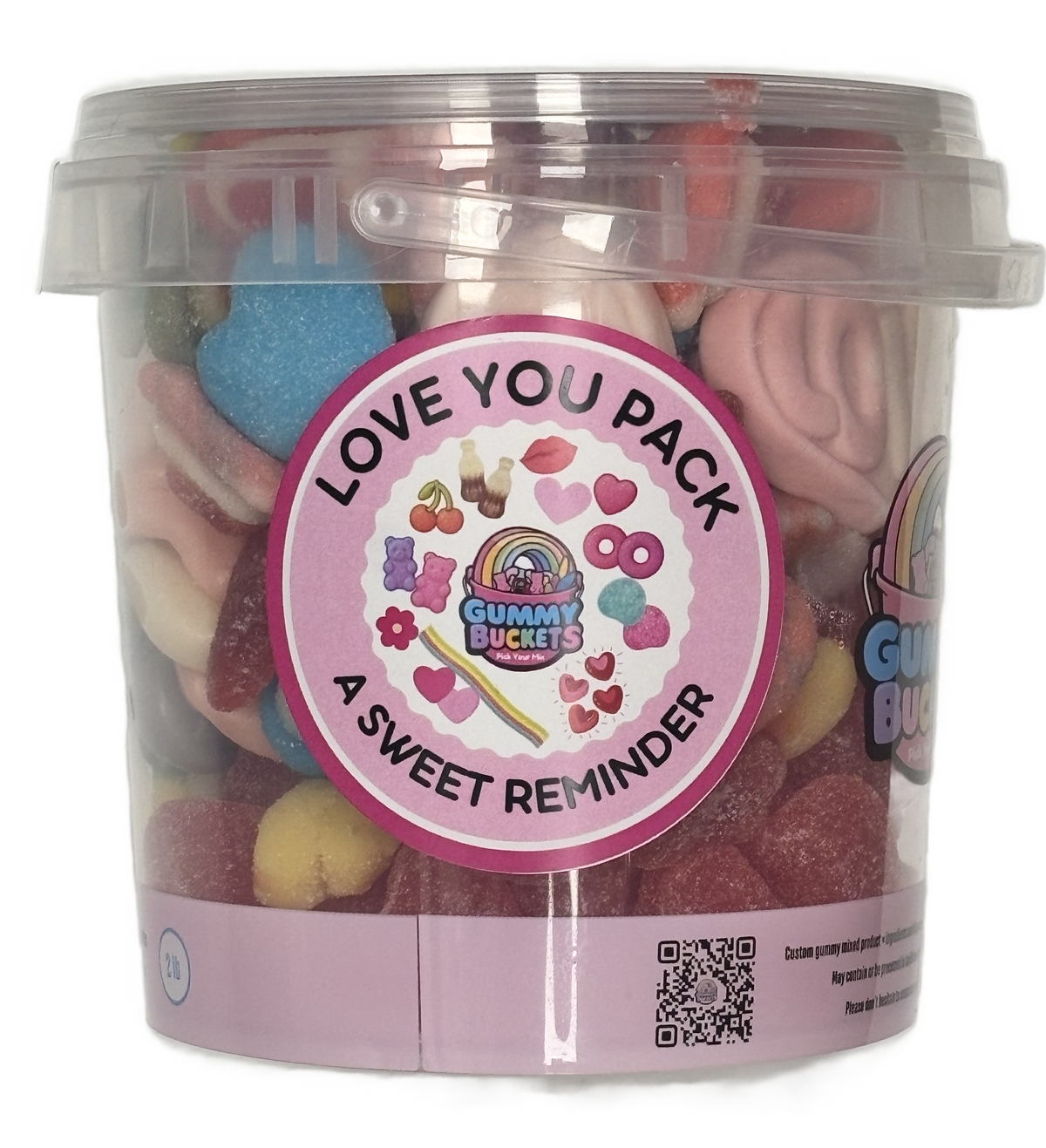 A clear plastic tub filled with assorted colorful gummy candies and sweets, featuring a round pink label that reads 'LOVE YOU PACK' and 'A SWEET REMINDER' with the Gummy Buckets logo. The tub is photographed on a plain white background.