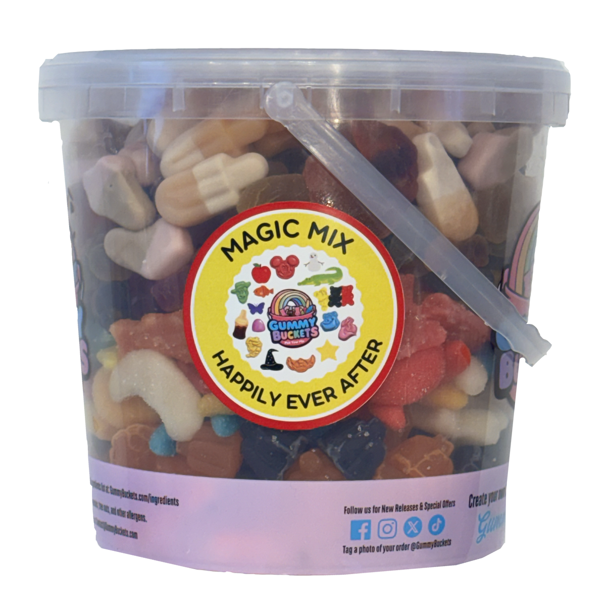 A clear plastic tub filled with assorted gummy candies and sweets, with a white lid and a large circular yellow label reading 'MAGIC MIX' and 'HAPPILY EVER AFTER.' The tub is photographed on a plain white background.