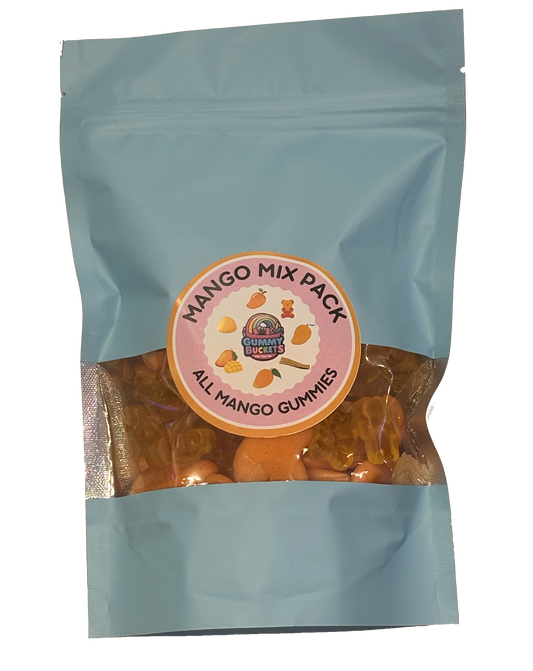 A light blue resealable stand-up pouch with a clear window showing golden orange mango-flavored gummy candies including bears and rings inside. A round pink and orange label on the front reads 'MANGO MIX PACK' and 'ALL MANGO GUMMIES' with the Gummy Buckets logo surrounded by illustrated mango icons in the center.