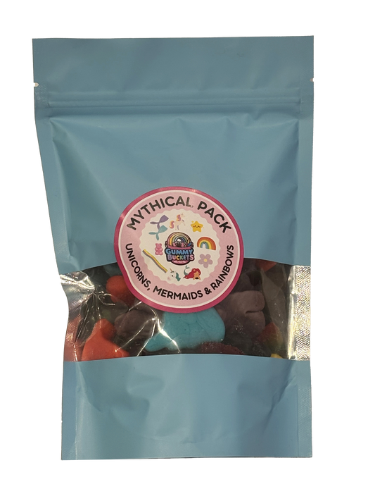 A light blue resealable stand-up pouch with a clear window showing a colorful assortment of mythical creature-shaped gummy candies including unicorns, mermaids, and rainbow shapes in blue, red, orange, and purple inside. A round pink label on the front reads 'MYTHICAL PACK' and 'UNICORNS, MERMAIDS & RAINBOWS' with the Gummy Buckets logo surrounded by illustrated mythical creature icons in the center.