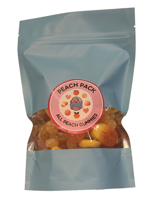 A light blue resealable stand-up pouch with a clear window showing golden peach-flavored gummy candies including rings and round peach shapes inside. A round pink label on the front reads 'PEACH PACK' and 'ALL PEACH GUMMIES' with the Gummy Buckets logo surrounded by illustrated peach and heart icons in the center.