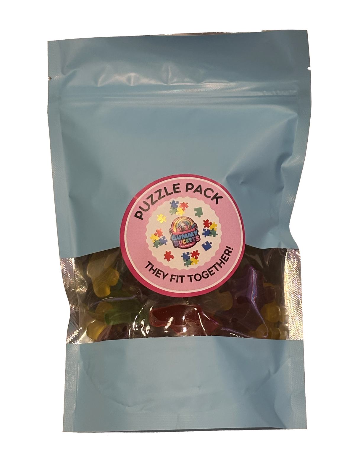 A light blue resealable stand-up pouch containing a mix of colorful gummy candies visible through a clear window, with a round pink label reading 'PUZZLE PACK' and 'THEY FIT TOGETHER!'.
