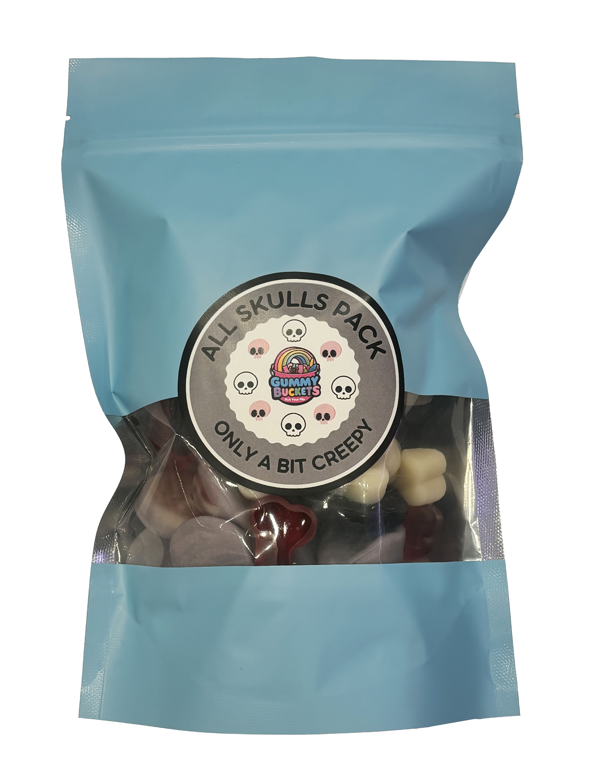 A light blue resealable stand-up pouch with a clear window showing black, red, and white skull-shaped gummy candies inside. A round dark gray label on the front reads 'ALL SKULLS PACK' and 'ONLY A BIT CREEPY' with the Gummy Buckets logo surrounded by illustrated skull icons in the center.