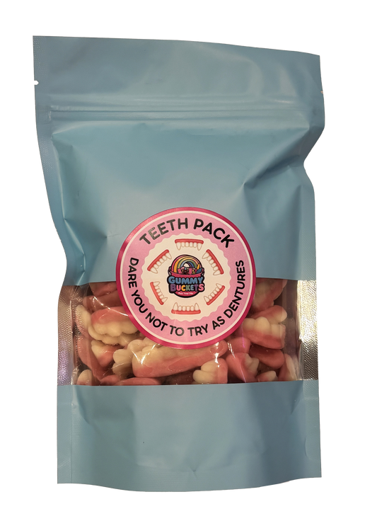 A light blue resealable pouch containing pink and off-white tooth-shaped gummy candies, with a round pink label reading 'TEETH PACK' and 'DARE YOU NOT TO TRY AS DENTURES.'.