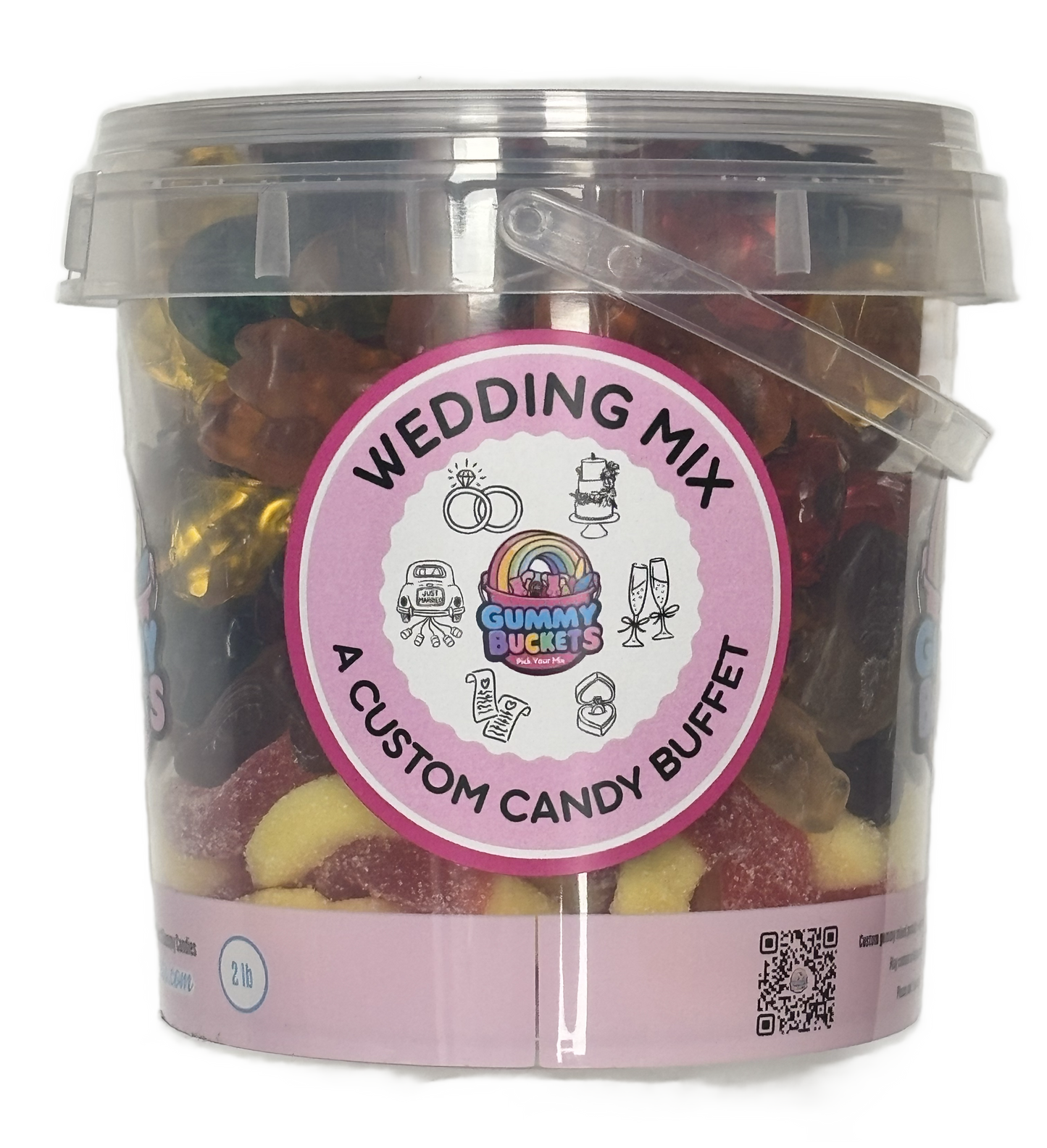 A clear plastic bucket filled with assorted gummy candies and wrapped sweets, labeled 'WEDDING MIX' and 'A CUSTOM CANDY BUFFET' by Gummy Buckets. The bucket has a pink circular label and a transparent lid with a handle.